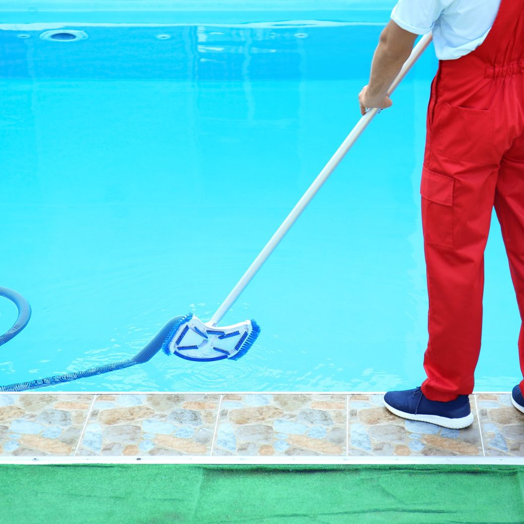 hombre limpiando piscina